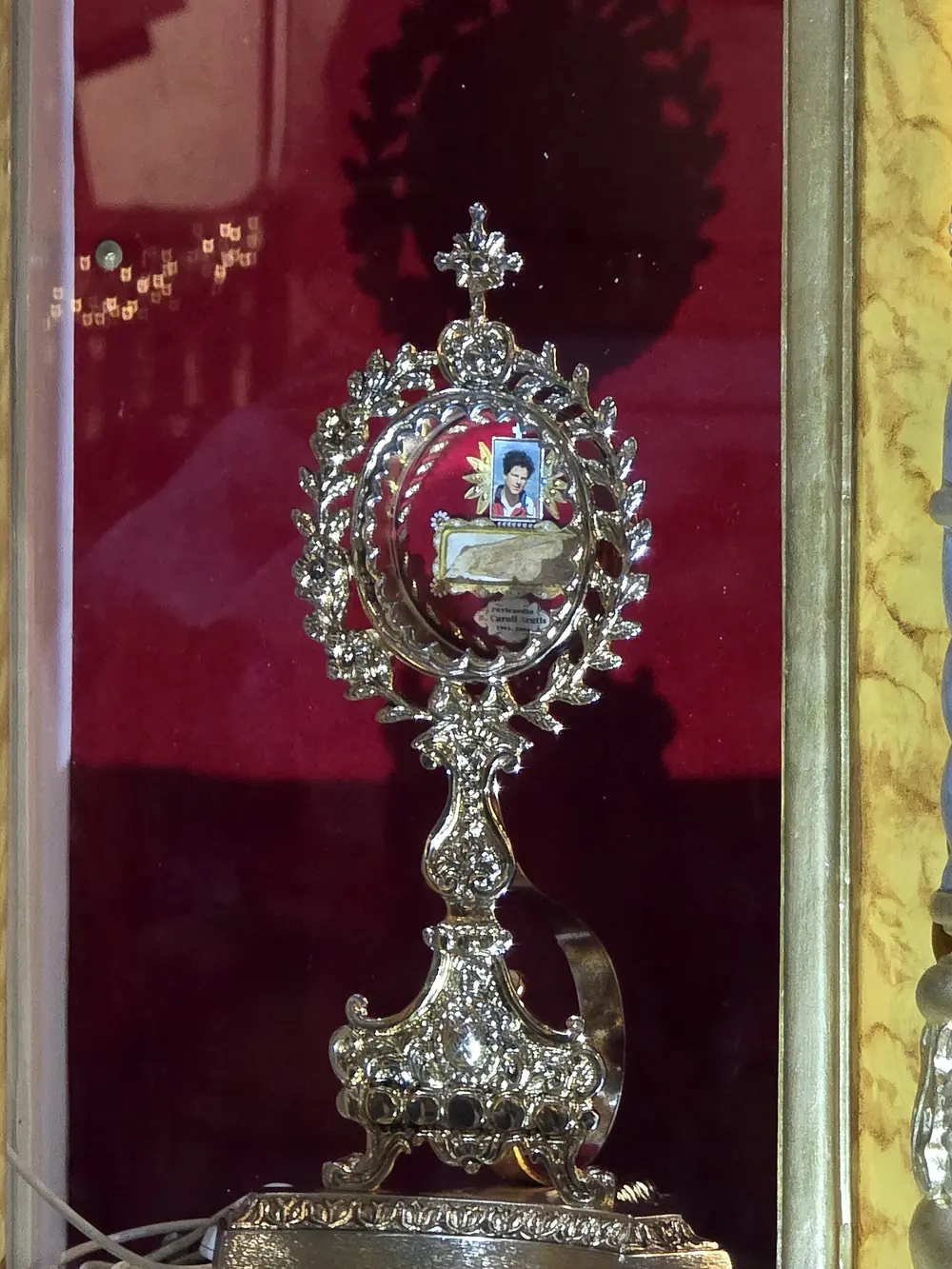 Relicário do pericárdio de São Carlo Acutis, sobre veludo vermelho